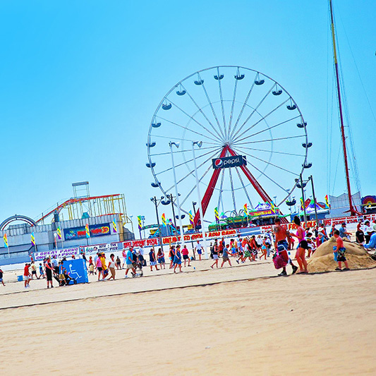 People on the beach with pier in the background