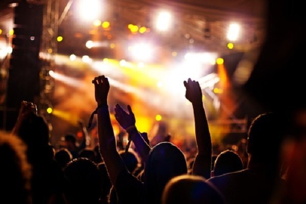 band in front of a large audience waving their hands