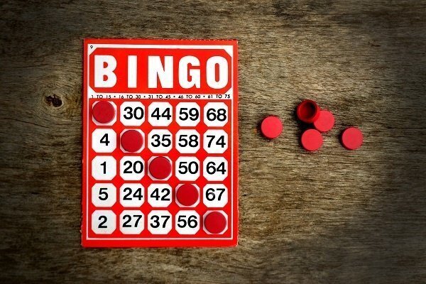 red and white bingo cards and red bingo chips